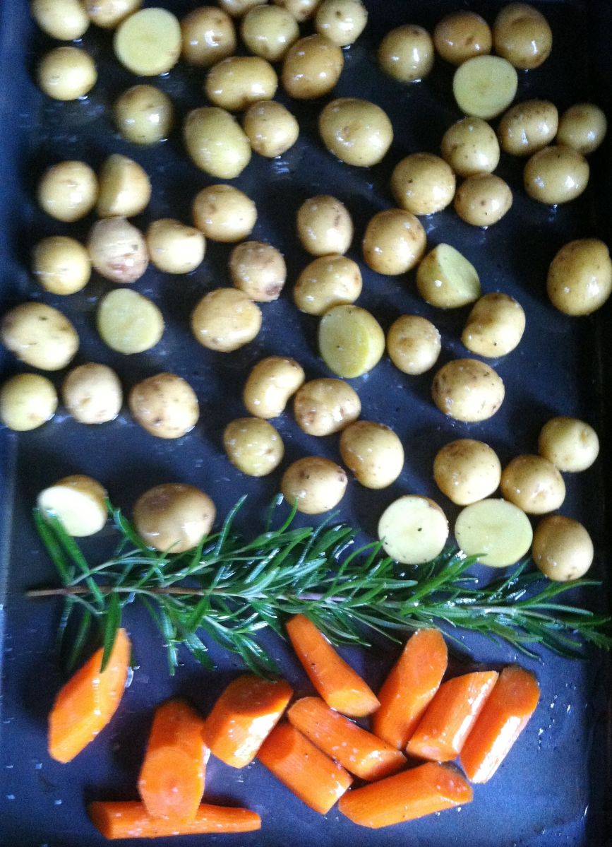 Carrots, rosemary, and potatoes go in first.